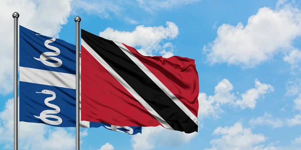 Martinik ve Trinidad ve Tobago bayrağı birlikte beyaz bulutlu mavi gökyüzüne karşı rüzgarda sallayarak. Diplomasi kavramı, uluslararası ilişkiler. — Stok fotoğraf