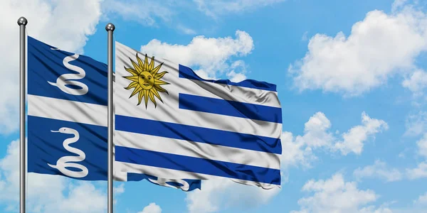 Η σημαία της Μαρτινίκας και της Ουρουγουάης κουνώντας τον άνεμο ενάντια στον γαλάζιο ουρανό. Φιλοσοφία της διπλωματίας, διεθνείς σχέσεις. — Φωτογραφία Αρχείου