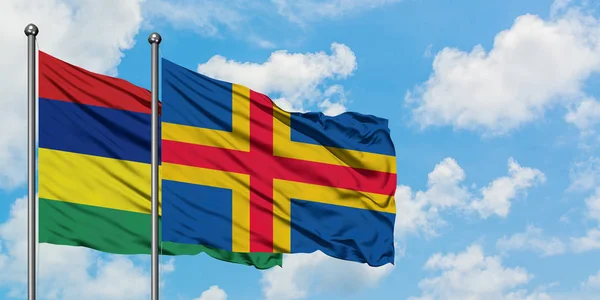 Mauritius and Aland Islands flag waving in the wind against white cloudy blue sky together. Diplomacy concept, international relations. — Stock Photo, Image