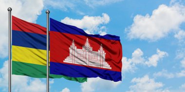 Mauritius ve Kamboçya bayrağı birlikte beyaz bulutlu mavi gökyüzüne karşı rüzgarda sallayarak. Diplomasi kavramı, uluslararası ilişkiler.