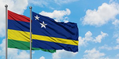 Mauritius ve Curacao bayrağı birlikte beyaz bulutlu mavi gökyüzüne karşı rüzgarda sallayarak. Diplomasi kavramı, uluslararası ilişkiler.