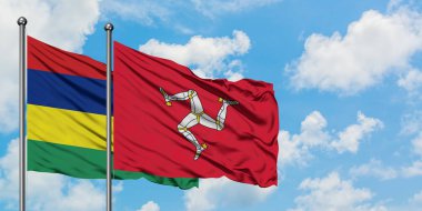 Mauritius ve Isle of Man bayrağı birlikte beyaz bulutlu mavi gökyüzüne karşı rüzgarda sallayarak. Diplomasi kavramı, uluslararası ilişkiler.