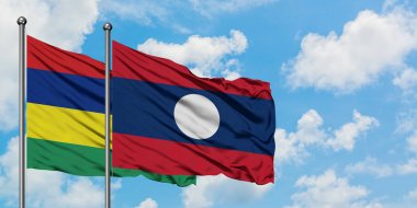 Mauritius ve Laos bayrağı birlikte beyaz bulutlu mavi gökyüzüne karşı rüzgarda sallayarak. Diplomasi kavramı, uluslararası ilişkiler.