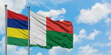 Mauritius ve Madagaskar bayrağı birlikte beyaz bulutlu mavi gökyüzüne karşı rüzgarda sallayarak. Diplomasi kavramı, uluslararası ilişkiler.
