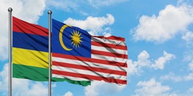 Mauritius ve Malezya bayrağı birlikte beyaz bulutlu mavi gökyüzüne karşı rüzgarda sallayarak. Diplomasi kavramı, uluslararası ilişkiler.