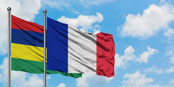 Bandera de Mauricio y Francia ondeando en el viento contra el cielo azul nublado blanco juntos. Concepto diplomático, relaciones internacionales . — Foto de Stock