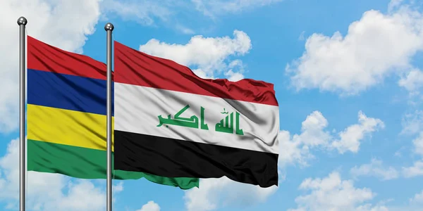 Mauricio y la bandera de Irak ondeando en el viento contra el cielo azul nublado blanco juntos. Concepto diplomático, relaciones internacionales . — Foto de Stock