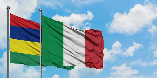 Bandera de Mauricio e Italia ondeando en el viento contra el cielo azul nublado blanco juntos. Concepto diplomático, relaciones internacionales . — Foto de Stock