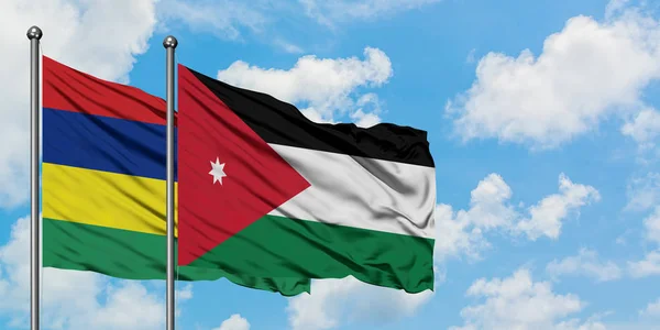 Bandera de Mauricio y Jordania ondeando en el viento contra el cielo azul nublado blanco juntos. Concepto diplomático, relaciones internacionales . — Foto de Stock