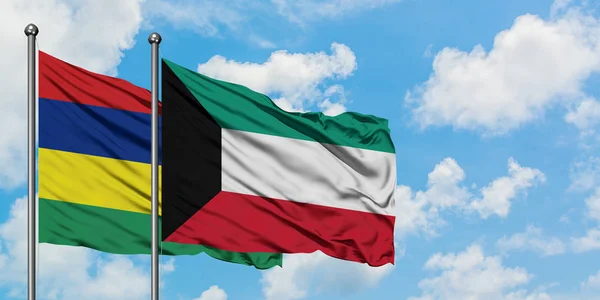 Bandera de Mauricio y Kuwait ondeando en el viento contra el cielo azul nublado blanco juntos. Concepto diplomático, relaciones internacionales . — Foto de Stock