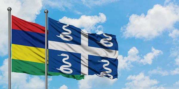 Mauricio y Martinica bandera ondeando en el viento contra el cielo azul nublado blanco juntos. Concepto diplomático, relaciones internacionales . — Foto de Stock