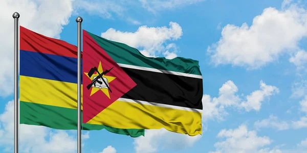 一緒に白い曇り青い空に対して風に手を振るモーリシャスとモザンビークの旗。外交概念、国際関係. — ストック写真