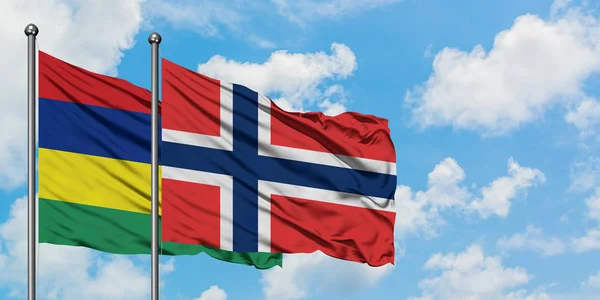 Bandera de Mauricio y Noruega ondeando en el viento contra el cielo azul nublado blanco juntos. Concepto diplomático, relaciones internacionales . — Foto de Stock