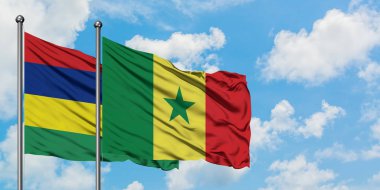 Mauritius ve Senegal bayrağı birlikte beyaz bulutlu mavi gökyüzüne karşı rüzgarda sallayarak. Diplomasi kavramı, uluslararası ilişkiler.