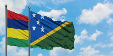 Mauritius ve Solomon Adaları bayrağı birlikte beyaz bulutlu mavi gökyüzüne karşı rüzgarda sallayarak. Diplomasi kavramı, uluslararası ilişkiler.
