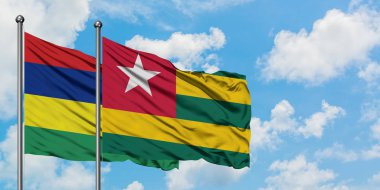Mauritius ve Togo bayrağı birlikte beyaz bulutlu mavi gökyüzüne karşı rüzgarda sallayarak. Diplomasi kavramı, uluslararası ilişkiler.