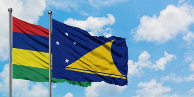 Mauritius ve Tokelau bayrağı birlikte beyaz bulutlu mavi gökyüzüne karşı rüzgarda sallayarak. Diplomasi kavramı, uluslararası ilişkiler.