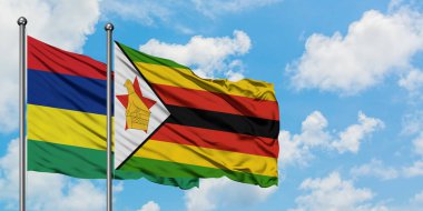 Mauritius ve Zimbabve bayrağı birlikte beyaz bulutlu mavi gökyüzüne karşı rüzgarda sallayarak. Diplomasi kavramı, uluslararası ilişkiler.