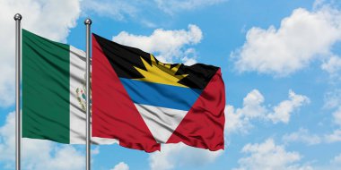 Meksika ve Antigua ve Barbuda bayrağı birlikte beyaz bulutlu mavi gökyüzüne karşı rüzgarda sallayarak. Diplomasi kavramı, uluslararası ilişkiler.