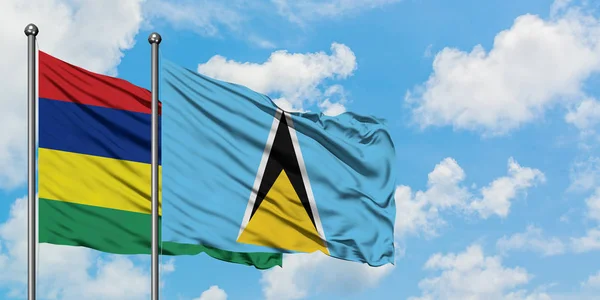 Mauritius och Saint Lucia flagga vifta i vinden mot vit grumlig blå himmel tillsammans. Diplomatisk koncept, internationella relationer. — Stockfoto