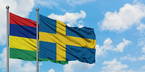 毛里求斯和瑞典国旗在风中飘扬，共同面对白泛蓝天。外交概念、国际关系. — 图库照片