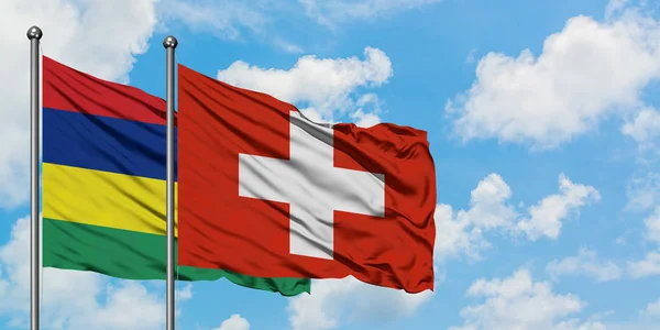 Mauritius i Szwajcaria flaga machając w wiatr przed białym zachmurzone błękitne niebo razem. Koncepcja dyplomacji, stosunki międzynarodowe. — Zdjęcie stockowe