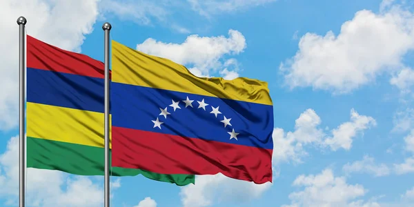 Drapeau de Maurice et du Venezuela agitant dans le vent contre ciel bleu nuageux blanc ensemble. Concept de diplomatie, relations internationales . — Photo