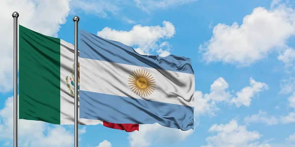 Bandera de México y Argentina ondeando en el viento contra el cielo azul nublado blanco juntos. Concepto diplomático, relaciones internacionales . — Foto de Stock