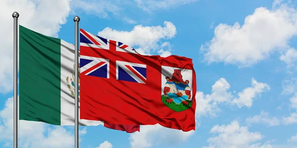 Bandera de México y Bermudas ondeando en el viento contra el cielo azul nublado blanco juntos. Concepto diplomático, relaciones internacionales . — Foto de Stock