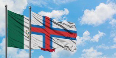 Meksika ve Faroe Adaları bayrağı birlikte beyaz bulutlu mavi gökyüzüne karşı rüzgarda sallayarak. Diplomasi kavramı, uluslararası ilişkiler.