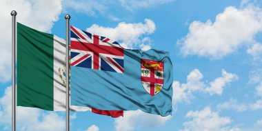 Meksika ve Fiji bayrağı birlikte beyaz bulutlu mavi gökyüzüne karşı rüzgarda sallayarak. Diplomasi kavramı, uluslararası ilişkiler.