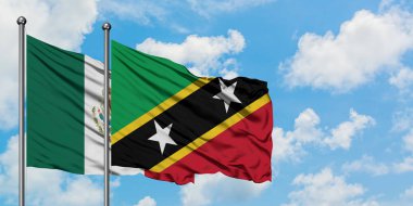 Meksika ve Saint Kitts ve Nevis bayrağı birlikte beyaz bulutlu mavi gökyüzüne karşı rüzgarda sallayarak. Diplomasi kavramı, uluslararası ilişkiler.