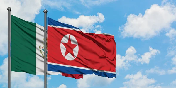 メキシコと北朝鮮の国旗は、一緒に白い曇り青い空に対して風に手を振る。外交概念、国際関係. — ストック写真