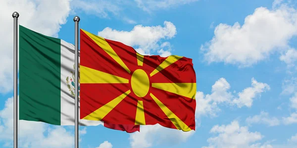 Bandera de México y Macedonia ondeando en el viento contra el cielo azul nublado blanco juntos. Concepto diplomático, relaciones internacionales . — Foto de Stock