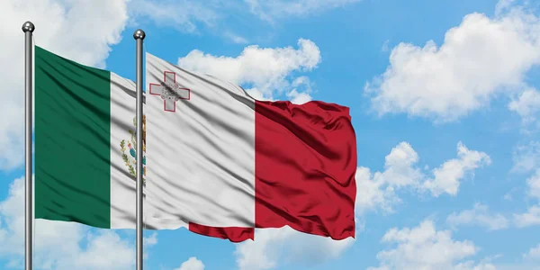 Bandera de México y Malta ondeando en el viento contra el cielo azul nublado blanco juntos. Concepto diplomático, relaciones internacionales . —  Fotos de Stock