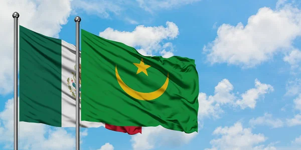 Bandera de México y Mauritania ondeando en el viento contra el cielo azul nublado blanco juntos. Concepto diplomático, relaciones internacionales . — Foto de Stock