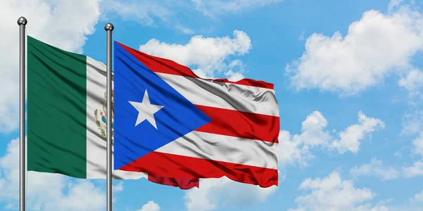 Bandera de México y Puerto Rico ondeando en el viento contra el cielo azul nublado blanco juntos. Concepto diplomático, relaciones internacionales . — Foto de Stock