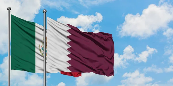 Bandera de México y Qatar ondeando en el viento contra el cielo azul nublado blanco juntos. Concepto diplomático, relaciones internacionales . —  Fotos de Stock