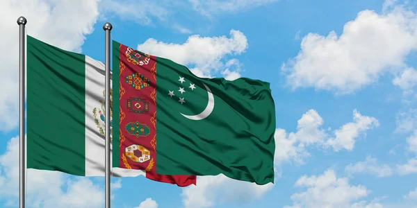 Bandera de México y Turkmenistán ondeando en el viento contra el cielo azul nublado blanco juntos. Concepto diplomático, relaciones internacionales . — Foto de Stock