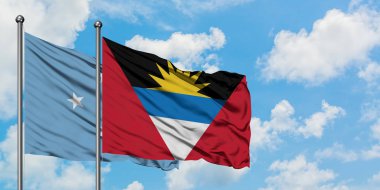 Mikronezya ve Antigua ve Barbuda bayrağı birlikte beyaz bulutlu mavi gökyüzüne karşı rüzgarda sallayarak. Diplomasi kavramı, uluslararası ilişkiler.