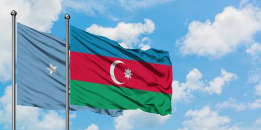Mikronezya ve Azerbaycan bayrağı birlikte beyaz bulutlu mavi gökyüzüne karşı rüzgarsal sallayarak. Diplomasi kavramı, uluslararası ilişkiler.