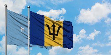 Mikronezya ve Barbados bayrağı birlikte beyaz bulutlu mavi gökyüzüne karşı rüzgarda sallayarak. Diplomasi kavramı, uluslararası ilişkiler.
