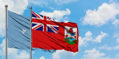 Mikronezya ve Bermuda bayrağı birlikte beyaz bulutlu mavi gökyüzüne karşı rüzgarda sallayarak. Diplomasi kavramı, uluslararası ilişkiler.