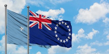 Mikronezya ve Cook Adaları bayrak birlikte beyaz bulutlu mavi gökyüzüne karşı rüzgarda sallayarak. Diplomasi kavramı, uluslararası ilişkiler.