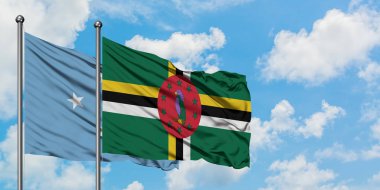 Mikronezya ve Dominika bayrağı birlikte beyaz bulutlu mavi gökyüzüne karşı rüzgarda sallayarak. Diplomasi kavramı, uluslararası ilişkiler.