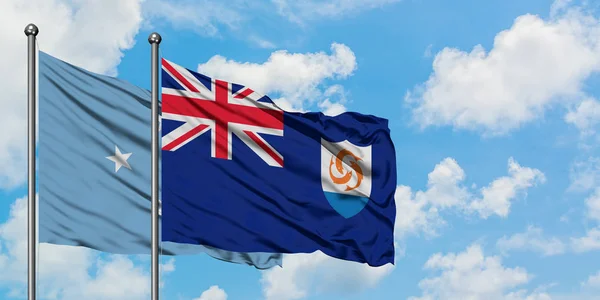 Micronesia y la bandera de Anguila ondeando en el viento contra el cielo azul nublado blanco juntos. Concepto diplomático, relaciones internacionales . — Foto de Stock