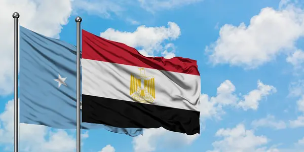 Micronesia y la bandera de Egipto ondeando en el viento contra el cielo azul nublado blanco juntos. Concepto diplomático, relaciones internacionales . — Foto de Stock