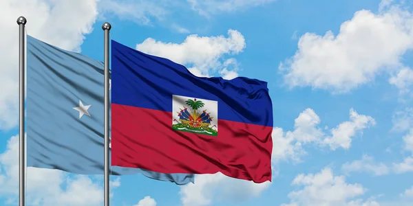 Mikronezya ve Haiti bayrağı birlikte beyaz bulutlu mavi gökyüzüne karşı rüzgarda sallayarak. Diplomasi kavramı, uluslararası ilişkiler. — Stok fotoğraf