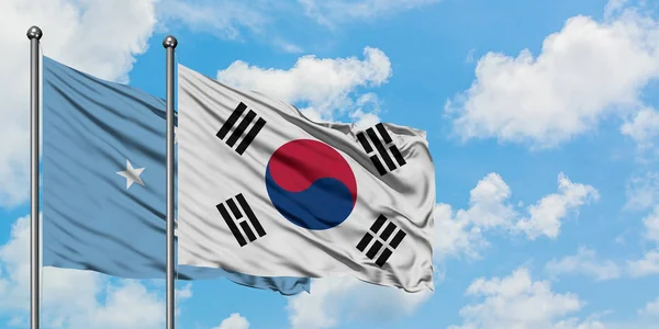 Mikronézia és Dél-Korea zászló integetett a szél ellen, fehér felhős kék ég együtt. Diplomáciai koncepció, nemzetközi kapcsolatok. — Stock Fotó