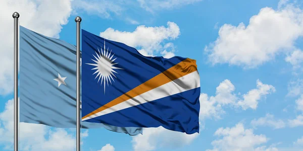 Mikronesien und die Marshallinseln wehen gemeinsam im Wind vor dem wolkenverhangenen blauen Himmel. Diplomatie-Konzept, internationale Beziehungen. — Stockfoto